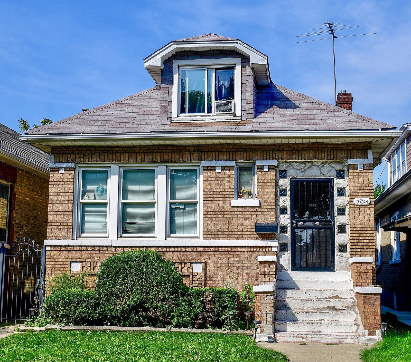 A brick Chicago bungalow with a hipped roof and front dormer